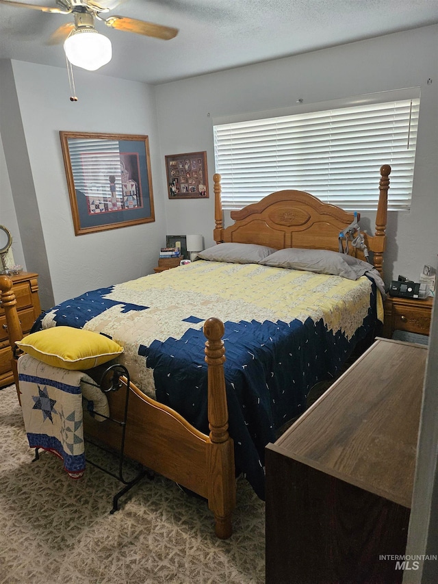 bedroom with a textured ceiling, carpet floors, and ceiling fan