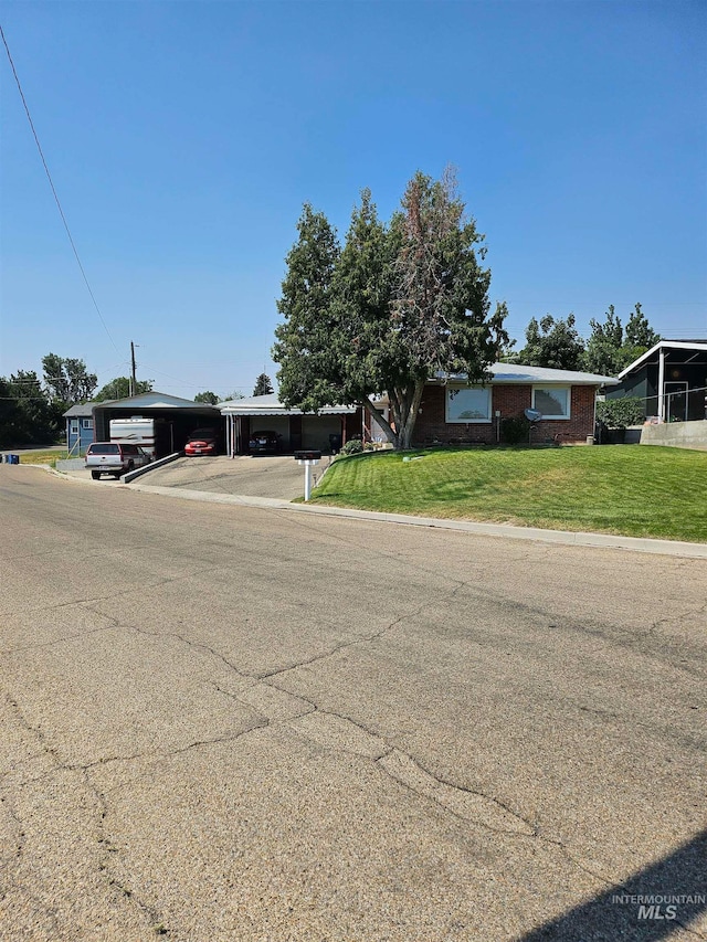 view of front of property with a front lawn and a carport