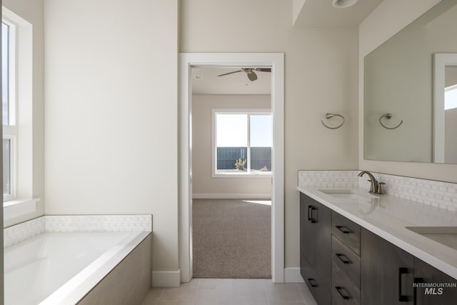 bathroom featuring a garden tub, double vanity, tasteful backsplash, a sink, and tile patterned flooring