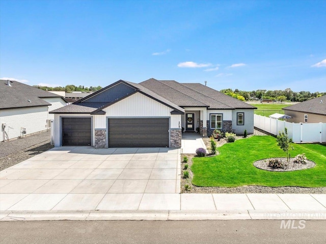 209 W 13th Ave, Jerome, ID 83338 - view of front facade featuring an attached garage, stone siding, driveway, and a shingled roof