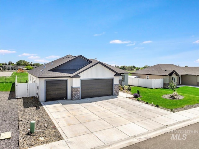 209 W 13th Ave, Jerome, ID 83338 - view of front of home with a garage, concrete driveway, stone siding, and a gate