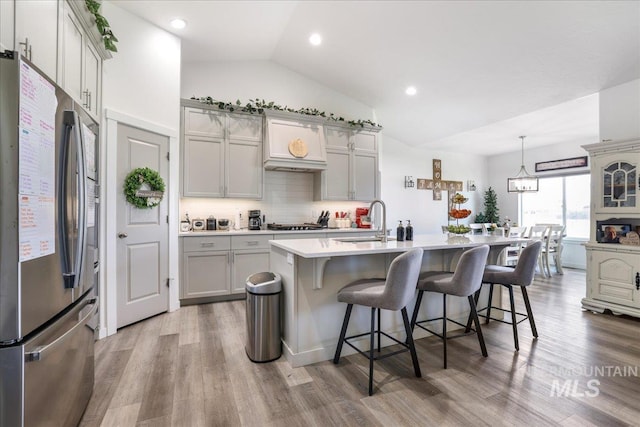 209 W 13th Ave, Jerome, ID 83338 - kitchen with freestanding refrigerator, a sink, light countertops, a breakfast bar area, and vaulted ceiling