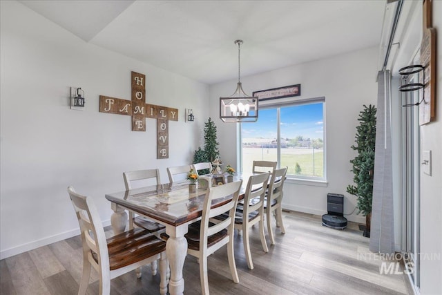 209 W 13th Ave, Jerome, ID 83338 - dining area featuring a chandelier, light wood-style floors, and baseboards