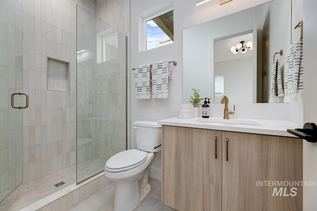 bathroom featuring vanity, tile patterned flooring, toilet, and a shower with door