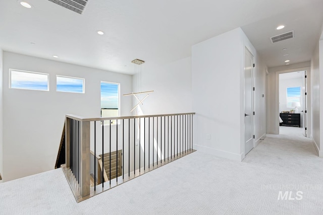 hallway featuring light colored carpet