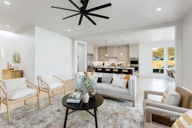 living room featuring light hardwood / wood-style floors and ceiling fan