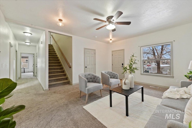 living room with ceiling fan, light carpet, and a textured ceiling