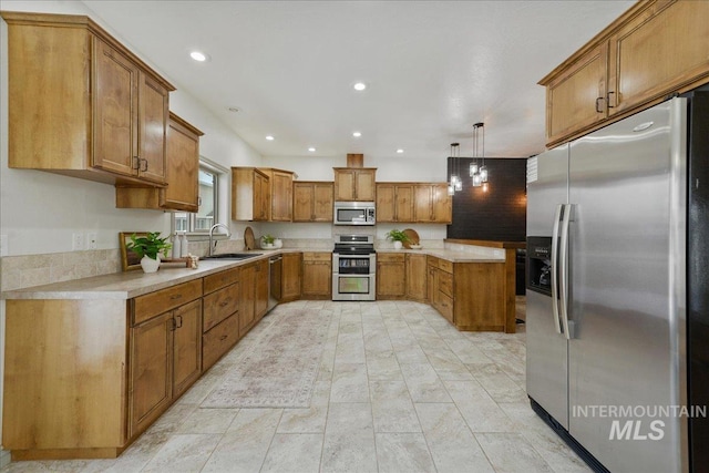 kitchen featuring appliances with stainless steel finishes, decorative light fixtures, and sink