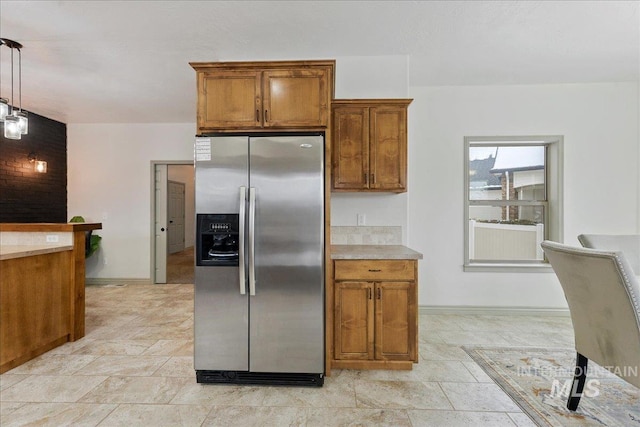 kitchen with stainless steel fridge and hanging light fixtures