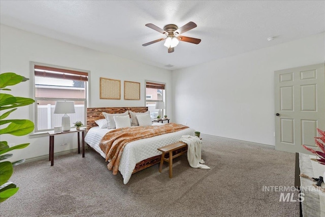 carpeted bedroom with multiple windows and ceiling fan