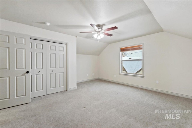 bonus room featuring vaulted ceiling and light colored carpet