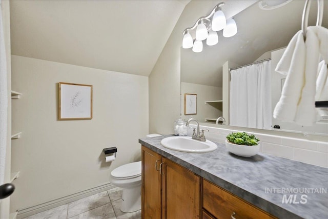 bathroom with tile patterned floors, vanity, toilet, and vaulted ceiling