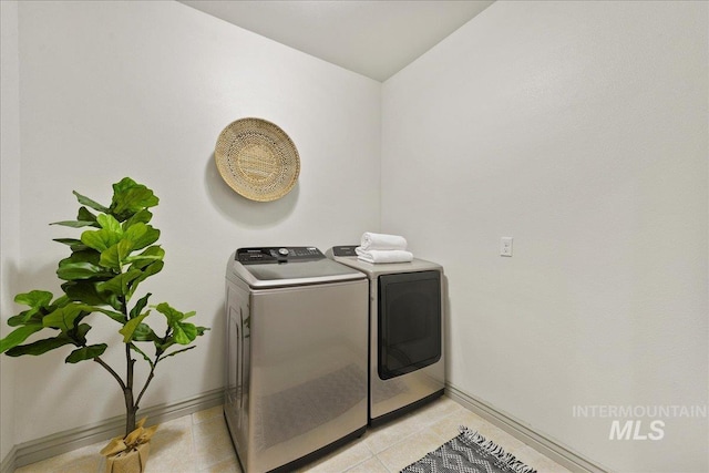 clothes washing area with light tile patterned floors and independent washer and dryer