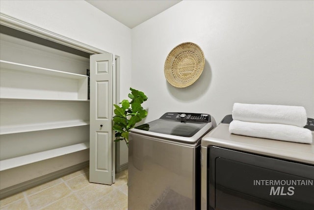 washroom featuring separate washer and dryer and light tile patterned floors