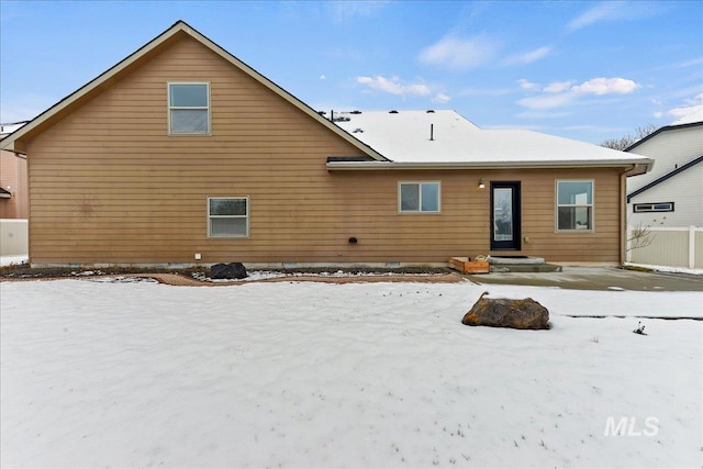 view of snow covered back of property