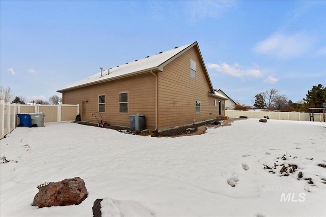 snow covered house featuring central air condition unit