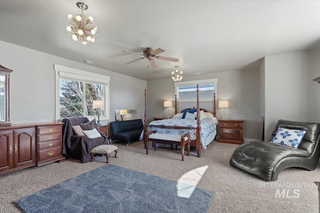 bedroom with visible vents, ceiling fan with notable chandelier, and carpet floors