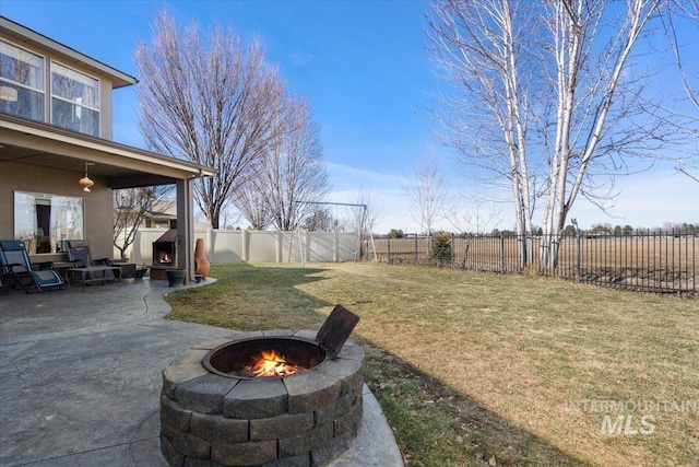 view of yard featuring a patio area, a fire pit, and a fenced backyard