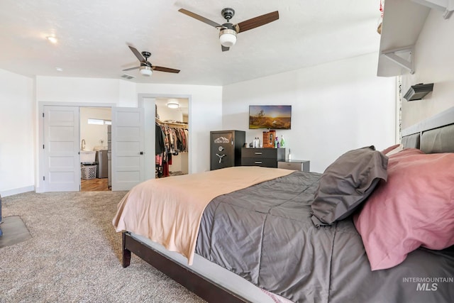 bedroom with light carpet, a walk in closet, a closet, and ceiling fan