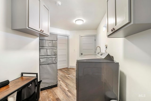 kitchen featuring gray cabinetry, light hardwood / wood-style flooring, and washer / dryer