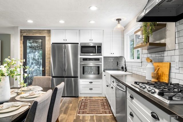 473 E Ranch Dr, Eagle, ID 83616 - kitchen featuring appliances with stainless steel finishes, a sink, white cabinets, under cabinet range hood, and recessed lighting