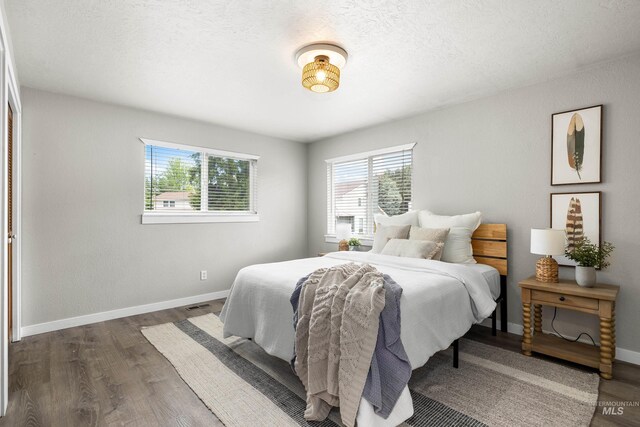 473 E Ranch Dr, Eagle, ID 83616 - bedroom with multiple windows, wood finished floors, baseboards, and a textured ceiling