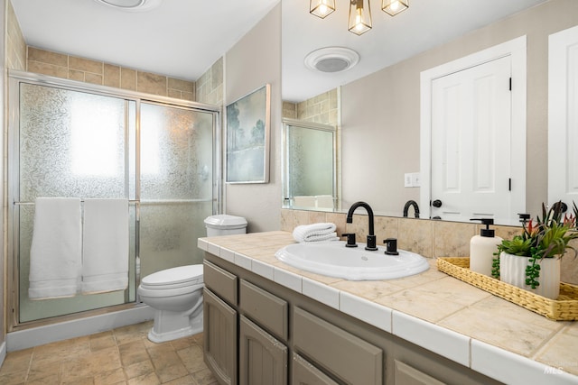 473 E Ranch Dr, Eagle, ID 83616 - bathroom with vanity, a stall shower, toilet, and stone finish floors