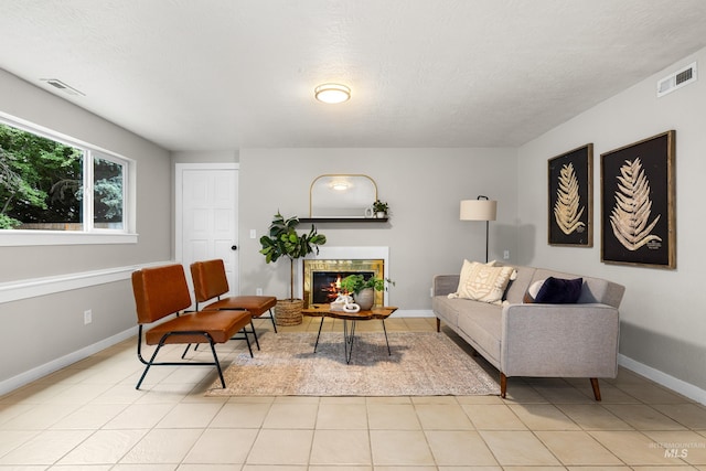 473 E Ranch Dr, Eagle, ID 83616 - living room featuring a fireplace, light tile patterned flooring, baseboards, and a textured ceiling