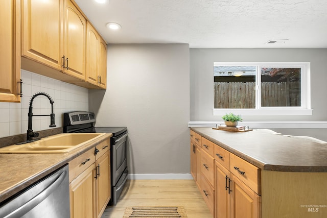 473 E Ranch Dr, Eagle, ID 83616 - kitchen featuring stainless steel appliances, a sink, light wood-style floors, tasteful backsplash, and light brown cabinetry