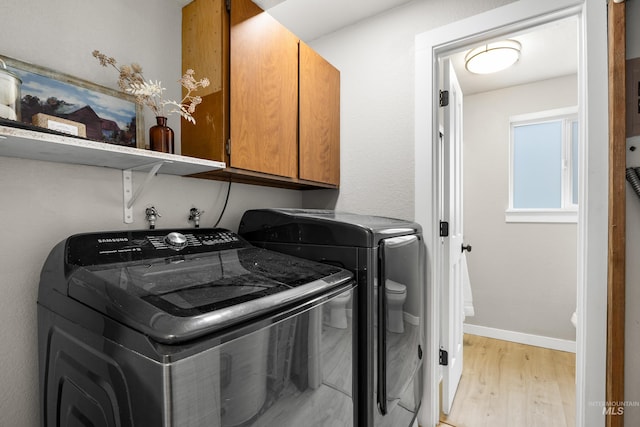 473 E Ranch Dr, Eagle, ID 83616 - washroom featuring cabinet space, light wood-style floors, separate washer and dryer, and baseboards