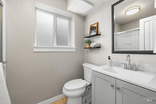 473 E Ranch Dr, Eagle, ID 83616 - full bath with vanity, toilet, wood finished floors, baseboards, and a shower with door