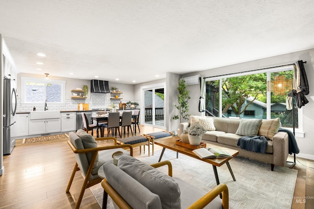 473 E Ranch Dr, Eagle, ID 83616 - living area featuring light wood finished floors, plenty of natural light, a wall mounted AC, recessed lighting, and a textured ceiling