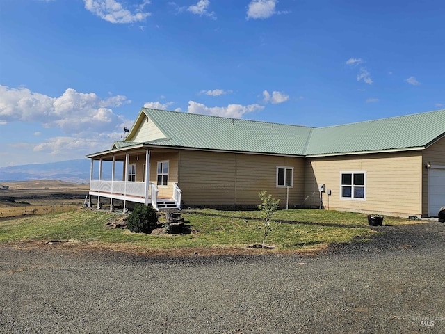 exterior space with a garage, metal roof, and a front lawn