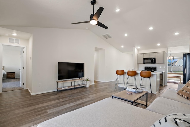 living area featuring visible vents, ceiling fan, wood finished floors, and baseboards