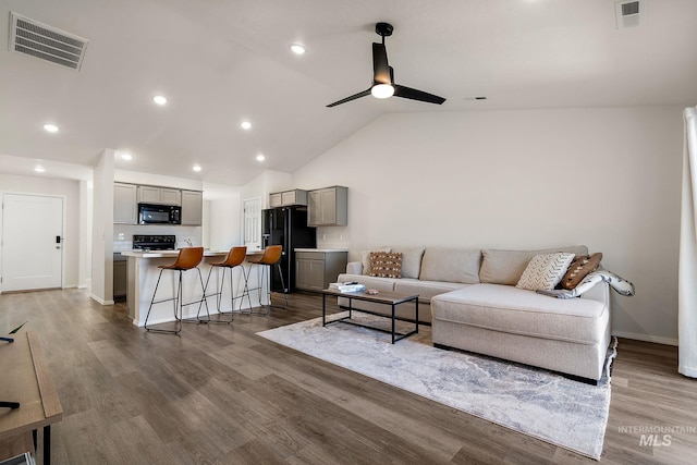 living room featuring a ceiling fan, visible vents, and wood finished floors