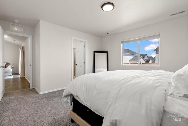 bedroom featuring visible vents, carpet floors, and baseboards