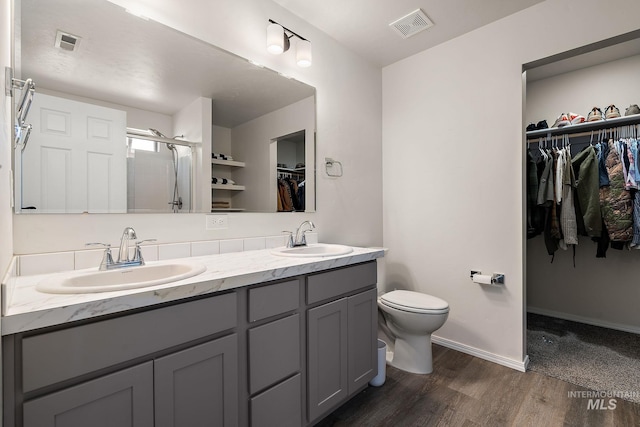 full bathroom featuring visible vents, toilet, a stall shower, and a sink