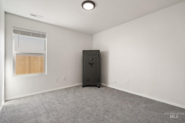 spare room featuring carpet, visible vents, plenty of natural light, and baseboards