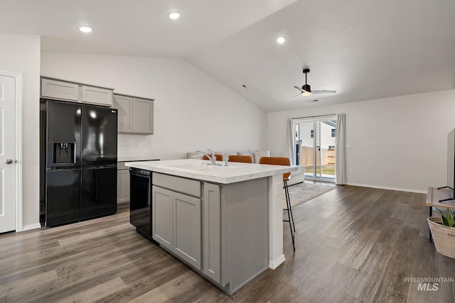 kitchen with a sink, gray cabinets, black appliances, a ceiling fan, and vaulted ceiling