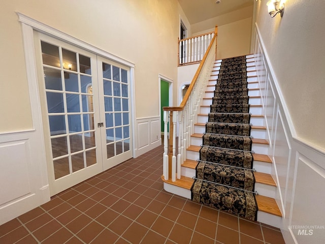 stairs featuring french doors and tile patterned floors