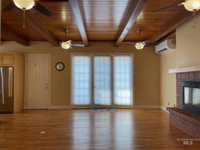 unfurnished living room with a fireplace, beamed ceiling, light wood-type flooring, a wall unit AC, and wood ceiling