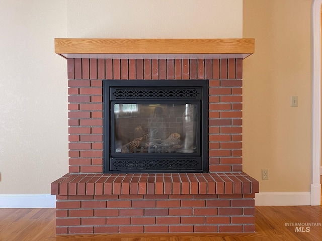 interior details featuring a fireplace and wood-type flooring