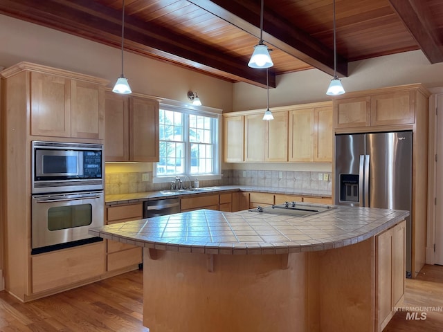 kitchen featuring light brown cabinetry, appliances with stainless steel finishes, and tile counters