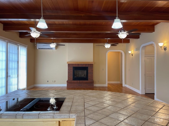 unfurnished living room with hardwood / wood-style flooring, a wall mounted AC, beamed ceiling, a brick fireplace, and wooden ceiling