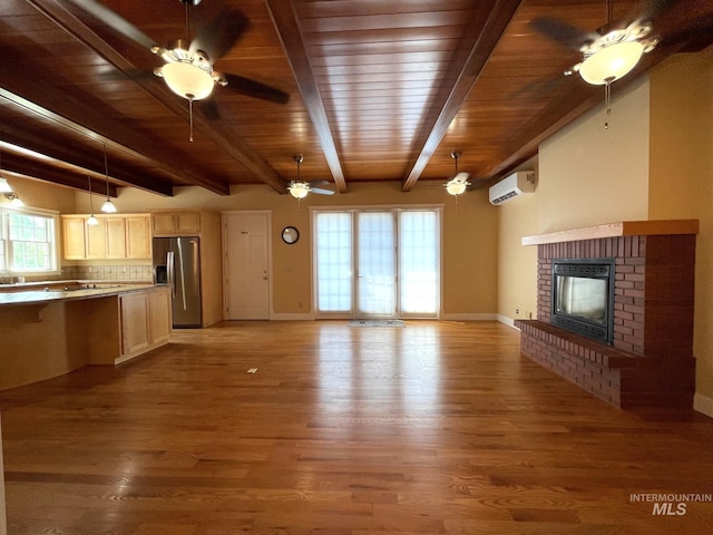 unfurnished living room with a fireplace, light hardwood / wood-style floors, a wall mounted air conditioner, and beam ceiling