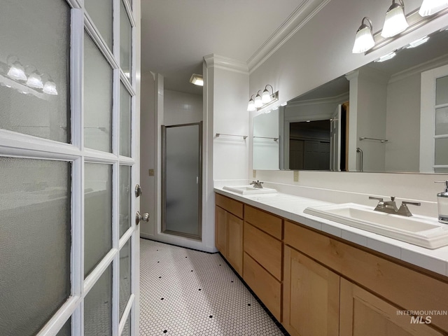 bathroom with ornamental molding, vanity, and a shower with shower door