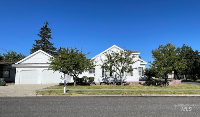 obstructed view of property featuring a front lawn and a garage