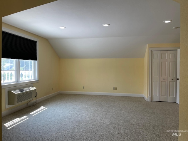 bonus room with lofted ceiling, a wall unit AC, and carpet