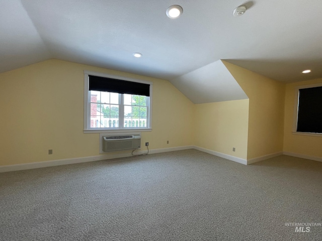 additional living space featuring lofted ceiling, an AC wall unit, and carpet flooring