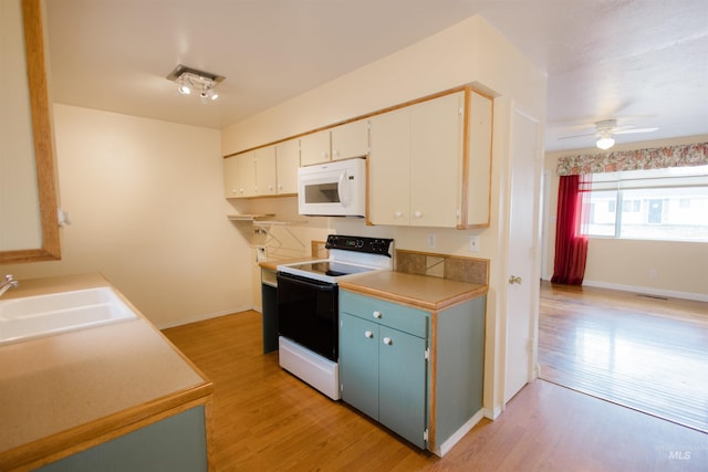 kitchen featuring white microwave, electric range oven, a sink, light wood-type flooring, and a ceiling fan